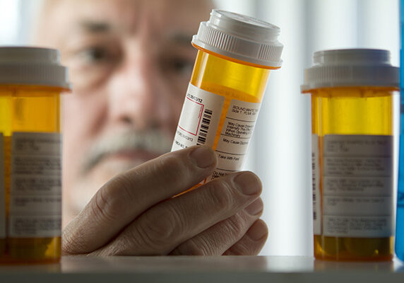 Man reaching for prescription form medicine cabinet Pharmaceuticals Product Liability